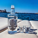 Ștefan cel Mare Moment: Bottle and two shot glasses of vodka on a boat with water and sky in the background