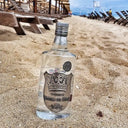 Ștefan cel Mare Moment: Vodka bottle on a sandy beach with lounge chairs in the background