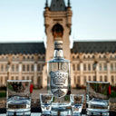 Vodka Ștefan cel Mare - Bottle and glasses of Vodka Stefan cel Mare with a castle-like building in the background