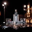 Vodka Ștefan cel Mare - Bottle of vodka with glasses on a reflective surface at night.
