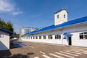 Voronskaya Vodka Factory - White building with blue roof under a clear blue sky