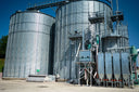 Voronskaya Vodka Factory - Large metal silos with industrial equipment against a blue sky