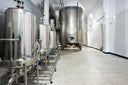 Voronskaya Vodka Factory - Stainless steel fermentation tanks in a brewery setting with 'Triago' branding.
