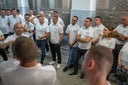 Voronskaya Vodka Factory - Group of people in white shirts standing together in a room with tiled walls.