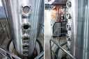 Voronskaya Vodka Factory - Two large stainless steel tanks with various pipes and valves in a brewery setting.