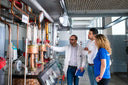 Voronskaya Vodka Factory - Three people in a laboratory setting, examining equipment.