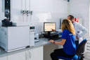 Voronskaya Vodka Factory - Two scientists working in a laboratory with a computer and equipment.